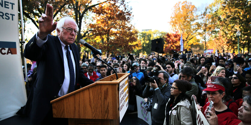 Senator Bernie Sanders spricht auf einem Rednerpult vor dem Kapitol vor begeisterten Anhängern und Trump-Gegnern