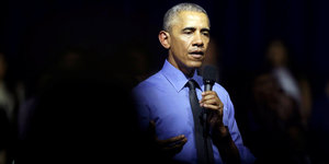 Barack Obama hält ein Mikrofon in der Hand