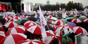 Protestierende Lehrer unter Regenschirmen