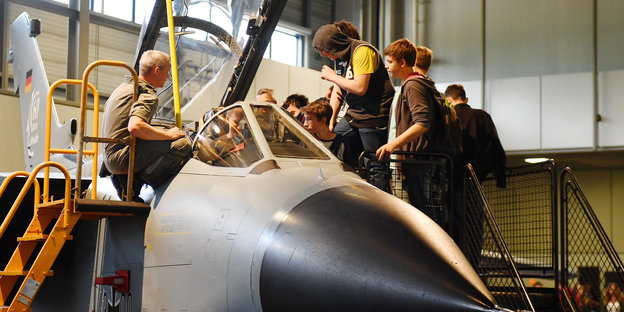 Jugendliche besichtigen ein Cockpit eines Tornado-Kampfflugzeuges.