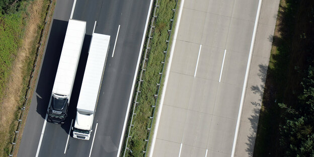 Vogelperspektive auf zwei Lastwagen während eines Überholmanövers auf der Autobahn