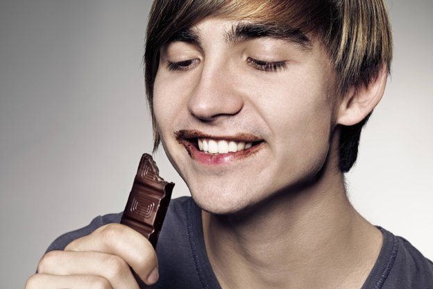 Ein junger Mann beisst in Schokolade