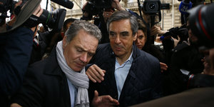 Der französische Politiker François Fillon zusammen mit einem weiteren Mann,umgeben von Journalisten