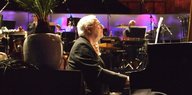 John Tilbury sitzt am Piano in einem Nachtclub
