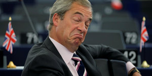 Nigel Farage zieht Mundwinkel mit heruntergezogenen Mundwinkeln und geschlossenen Augen