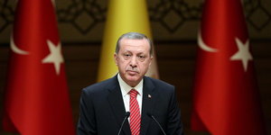 Ein Mann steht zwischen zwei Türkei-Flaggen