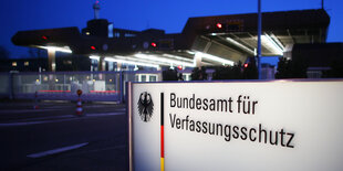 Vor einer Einfahrt steht ein Schild mit der Aufschrift „Bundesamt für Verfassungsschutz“