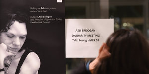 Eine Besucherin steht auf der Frankfurter Buchmesse vor einem Plakat, das auf eine Solidaritätsveranstaltung für die inhaftierte türkische Schriftstellerin Asli Erdogan hinweist