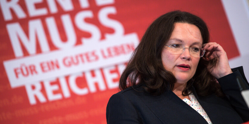 Andrea Nahles steht vor einer Wand mit einem DGB-Slogan