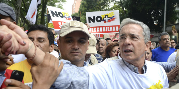 Ex-Präsident und Oppositionsführer Alvaro Uribe schüttelt auf einer Demonstration gegen das Friedensabkommen die Hand eines Unterstützers