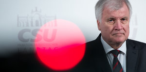 Bayerns Ministerpräsident Horst Seehofer. Im Vordegrund ein roter Punkt, der durch eine Lichtspiegelung entsteht