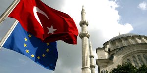Eine Türkeiflagge und eine EU-Flagge wehen vor der Nur-u Osmaniye Moschee in Istanbul