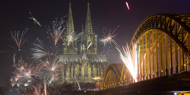 Feuerwerkskörper explodieren am 1. Januar 2016 in Köln über der Kulisse der Altstadt und des Doms