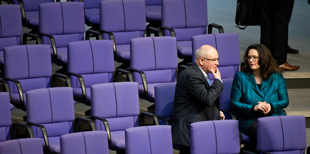 Arbeitsministerin Andrea Nahles und der CDU-Fraktionsvorsitzende Volker Kauder sitzen nebeneinander in den ansonsten leeren Stuhlreihen im Bundestag