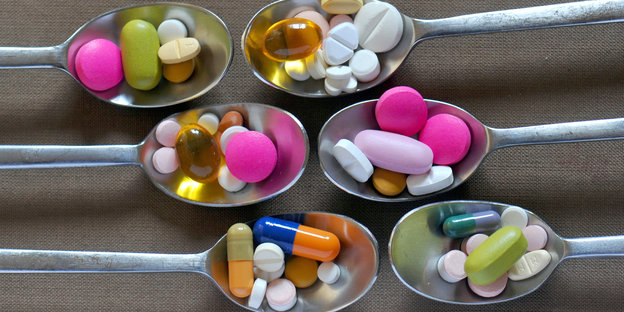 Tabletten in verschiedenen Farben auf Teelöffeln