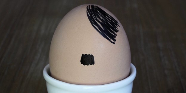 Auf ein Ei in einem Eierbecher sind ein Hitlerbart und die für Hitler typische Seitenscheitel-Frisur gemalt