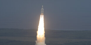 Eine Rakete steigt in den dunklen Himmel und zieht einen Feuerschweif nach sich