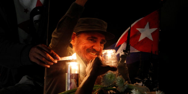 Vor einem Foto von Fidel Castro werden Kerzen angezündet