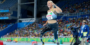 Eine junge blonde frau mit Beinprothesen springt