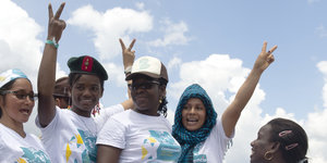 Mehrere Frauen zeigen das Victory-Zeichen und lächeln