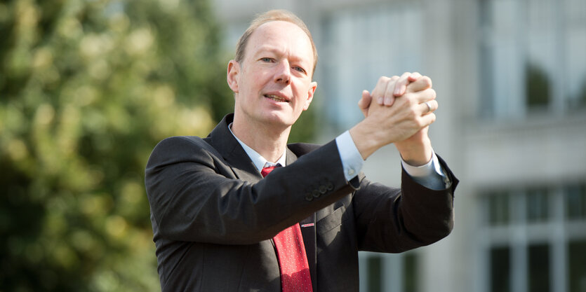 Martin Sonneborn hebt seine zusammengelegten Hände in siegreicher Pose in die Höhe