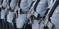 Soldaten, die Sturmgewehren vor dem Bauch tragen