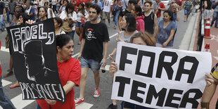 Demonstrant_innen halten Schilder, auf denen sie Amtsenthebung Temers und die Einsetzung Fidel Castros zum Präsidenten fordern