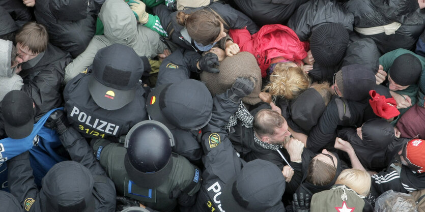 Polizist_innen stehen in einer Menschenmenge