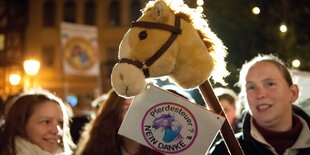 Zwei Frauen halten ein Steckenpferd bei einer Demonstration