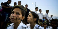 Eine junge Frau mit Barett und Uniform hat sich anlässlich der Gedenkfeier für Fidel Castro den Namen "Fidel" ins Gesicht geschrieben