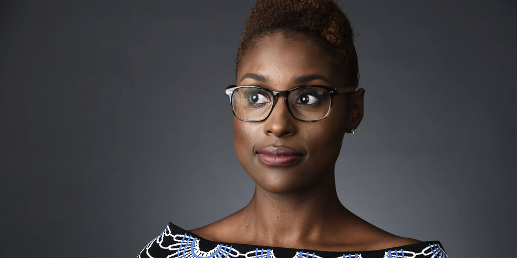 Ein Porträt der Comedian Issa Rae vor einem neutralen, grauen Hintergrund