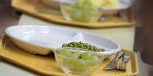Grüne Erbsen und Weintrauben auf einem Mensa-Tablett