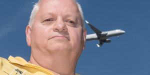 Ein Mann in Nahaufnahme und ein Flugzeug