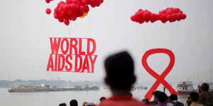 Menschen, Ballons und Aids-Symbole