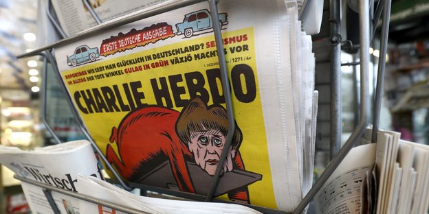 Die erste Ausgabe in einem Zeitungsständer. Auf dem Titelbild ist eine Karrikatur von Angela Merkel zu sehen.