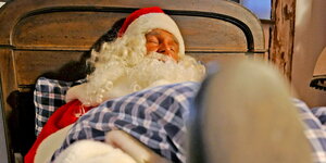 Der Weihnachtsmann liegt schlafend im Bett