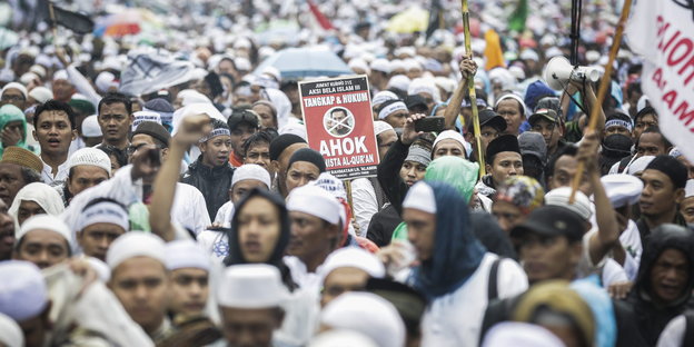 Viele Menschen mit weißen Kappen demonstrieren