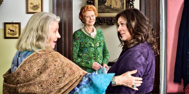 Drei Frauen mittleren Alters stehen in einem Zimmer