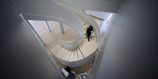 Eine Person geht eine spiralförmige Treppe hinab