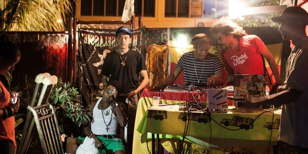 Männer stehen neben einem DJ-Pult