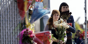 Frauen mit Blumen in der Hand, davor noch mehr Blumen