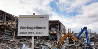 Vor einem Haufen Schrott steht ein Schild mit der Aufschrift „Werksgelände Adam Opel GmbH