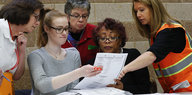 Mehrere Frauen beugen sich über einen Wahlzettel