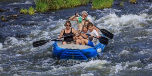 Eine Familie im Schlauchboot im Wildwasser