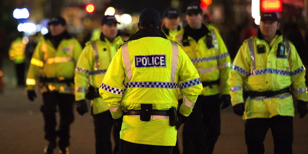 Britische Polizisten in gelben Jacken