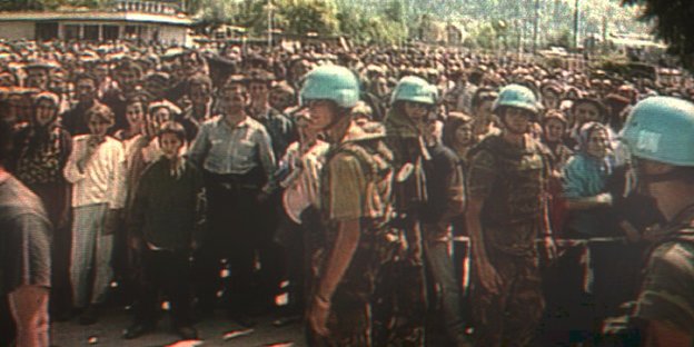 Hunderte Zivilisten und UN-Soldaten i stehen auf einem Platz in Bosnien-Herzegowina