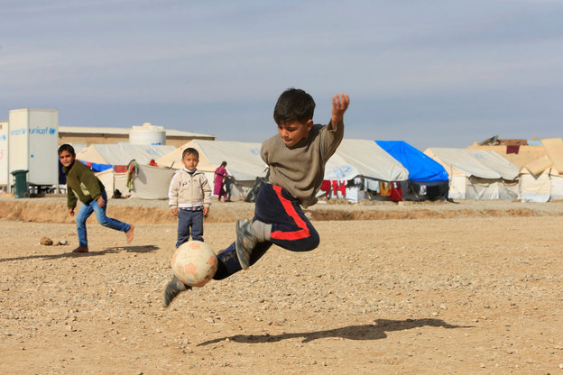 Ein Junge springt mit einem Fußball am Fuß
