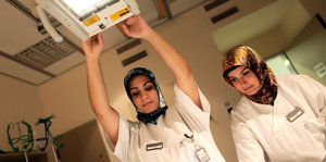 Zwei medizinisch-technische Assistentinnen tragen Kopftuch