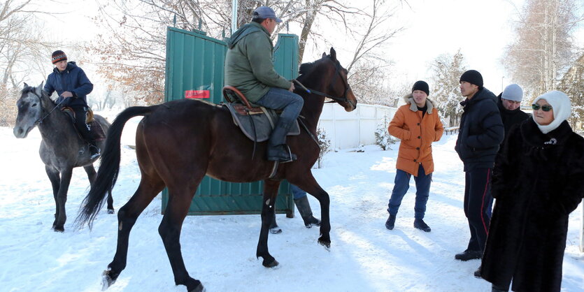 zwei Männer reiten im Schnee