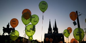 Mit roten und grünen Luftballons wird in Köln gegen Gewalt an Frauen demonstriert